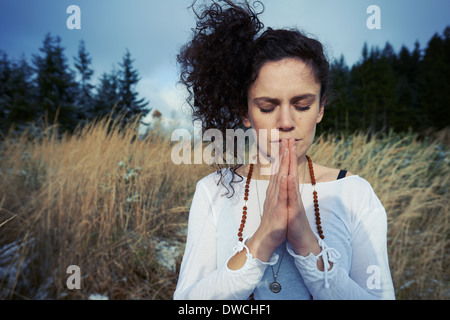 Mid adult woman meditating in forest