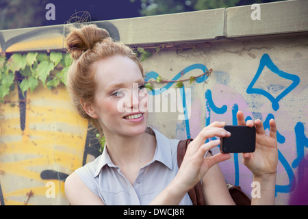 Young woman taking photograph on smartphone Stock Photo
