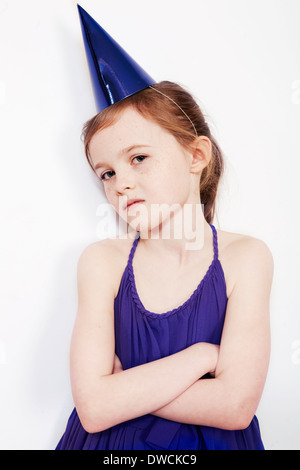 Portrait of girl wearing party hat with arms folded Stock Photo