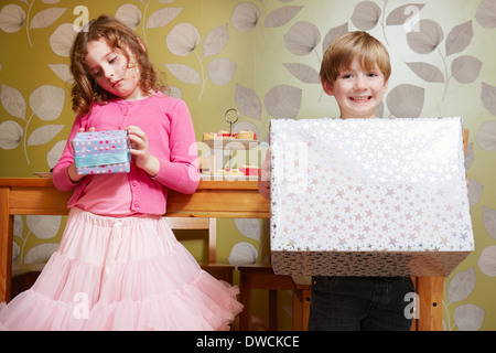 Boy and girl holding large and small present Stock Photo