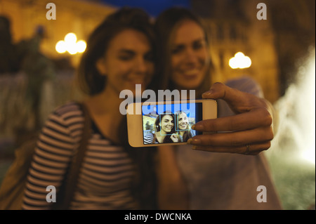 Two young women posing for self portrait, Plaza de la Virgen, Valencia, Spain Stock Photo