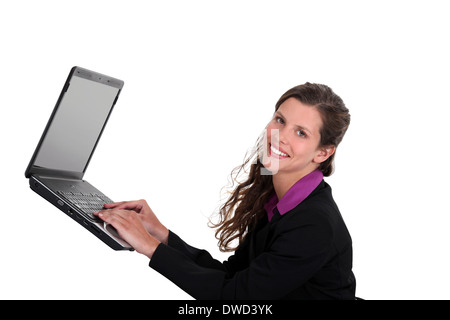 Woman typing on a laptop in mid-air Stock Photo
