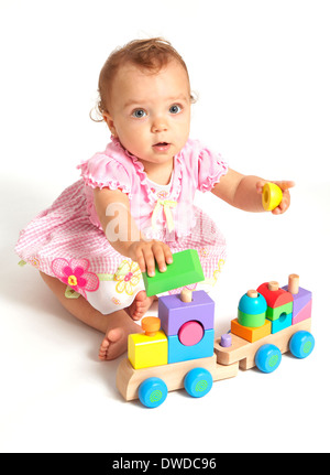 Baby girl playing with wooden train toy Stock Photo