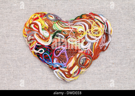 entangled threads, heart shape on burlap background Stock Photo