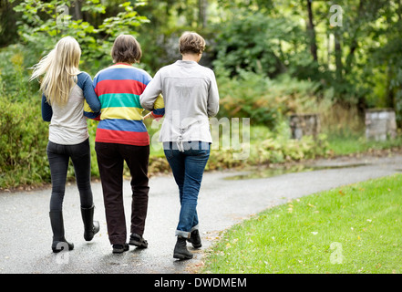 Rear view of three generation females walking on street at park Stock Photo