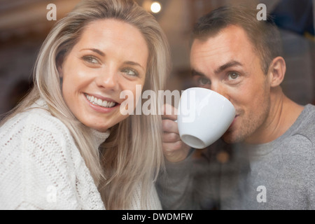 Happy couple looking out of cafe window Stock Photo
