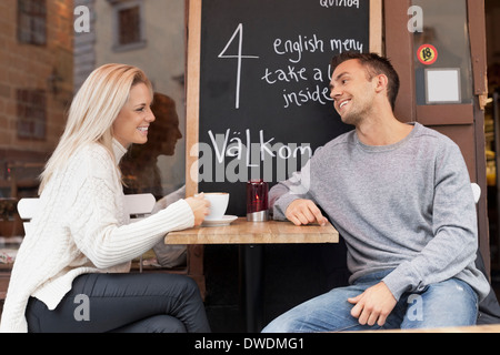 Young couple spending leisure time at outdoor cafe Stock Photo