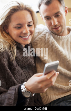 Young couple using mobile phone together on ferry Stock Photo