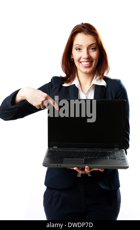 Smiling businesswoman holding laptop and pointing on it isolated on a white background Stock Photo