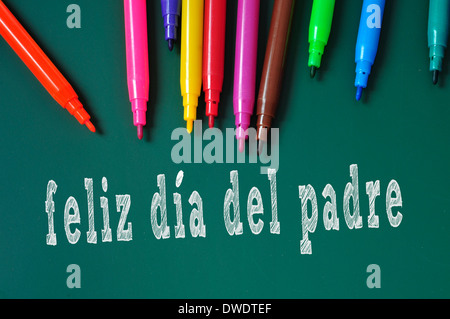 feliz dia del padre, happy fathers day written in spanish in a chalkboard, and some felt-tip pens of different colors Stock Photo