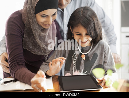 Muslim couple with daughter using digital tablet at home Stock Photo