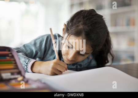 Girl studying at table in house Stock Photo