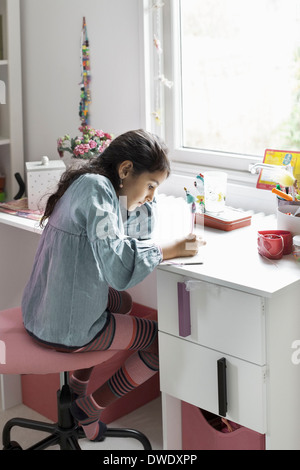 Girl studying at desk in house Stock Photo