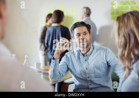 Businessman discussing with colleagues in conference room Stock Photo