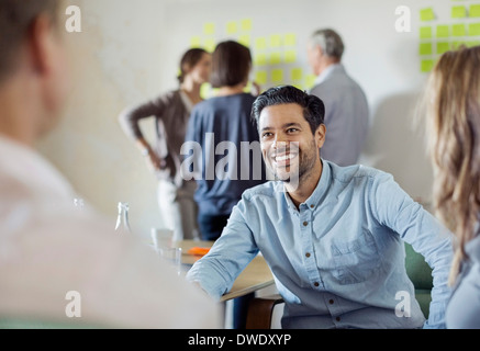 Happy businessman discussing with colleagues in board room Stock Photo