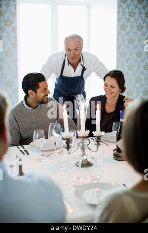 Senior chef talking to business people at dining table in restaurant Stock Photo