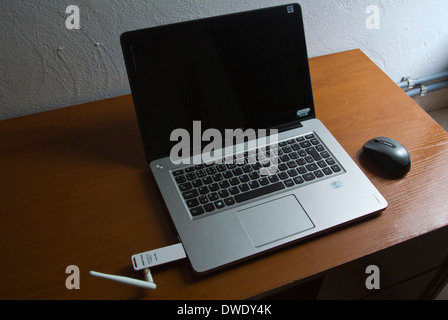 150Mbps High Gain Wireless USB Adapter attached into a Lenovo ultrabook for internet access and a wireless bluetooth mouse Stock Photo
