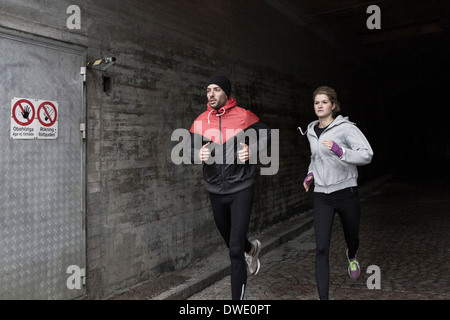 Sporty couple running in tunnel Stock Photo