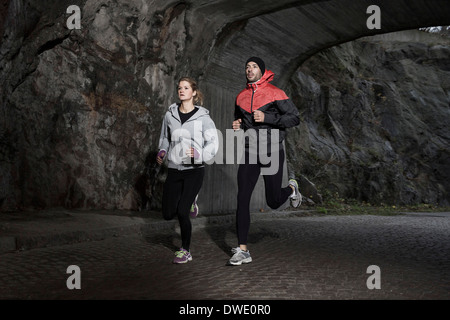 Sporty couple jogging in tunnel Stock Photo