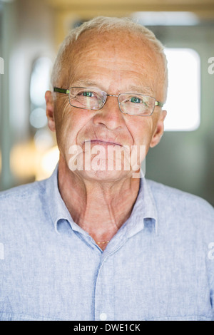 Portrait of confident senior man smiling indoors Stock Photo