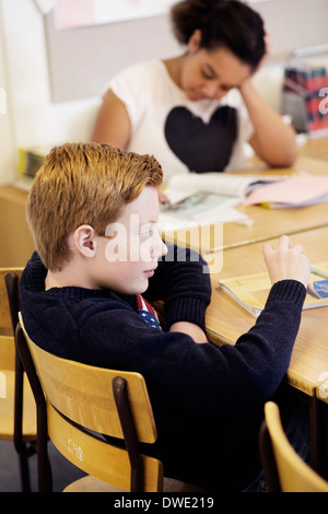 School students sitting at desk in classroom Stock Photo