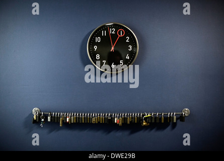 Padlocks hanging on railing with clock at gym's locker room Stock Photo