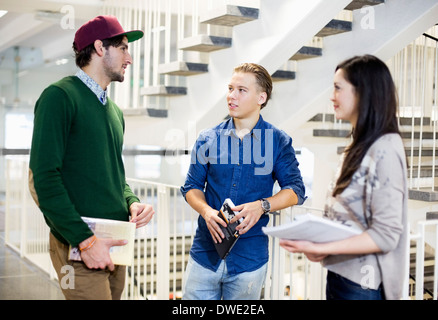 Young students conversing by railing i university Stock Photo