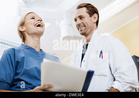 Happy doctor with nurse holding report in hospital Stock Photo