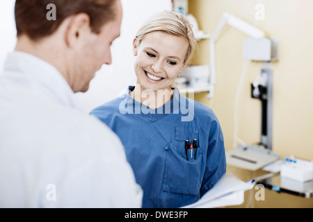 Young nurse with doctor reading report in hospital Stock Photo