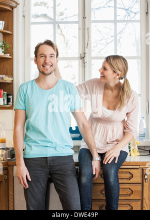 Happy mid adult couple spending leisure time in kitchen Stock Photo