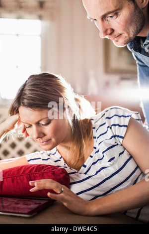 Couple using digital tablet in house Stock Photo