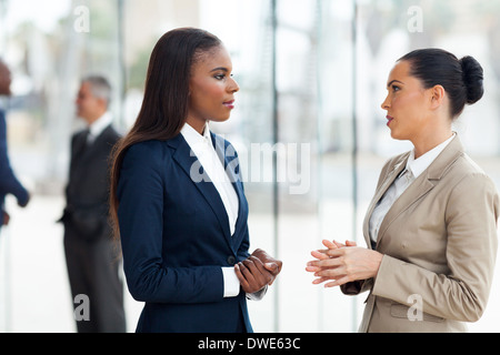 successful female colleagues having conversation in office Stock Photo