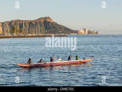 Honolulu, Hawaii, USA - Group of boys and girls paddle an outrigger Hawaiian canoe in the harbor of Honolulu Stock Photo