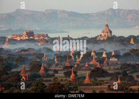 The temples of the Archaeological Zone in Bagan in the early morning sunlight. In the distance is the Irrawaddy River. Myanmar Stock Photo