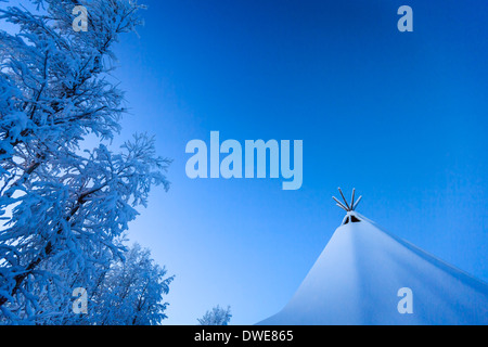 Sami tent and trees in cold winter temperatures of -47 celsius. Close to the IceHotel, Lapland, Sweden Stock Photo