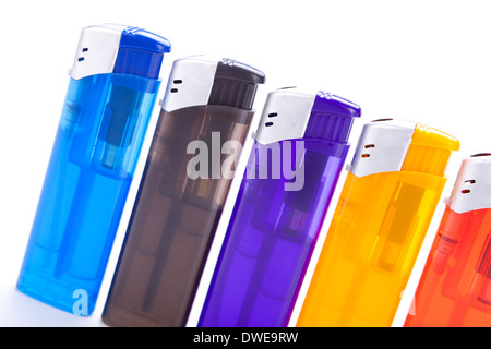 Row of vividly coloured plastic disposable lighters for smokers in red, yellow, two shades of blue and black isolated on a white background Stock Photo