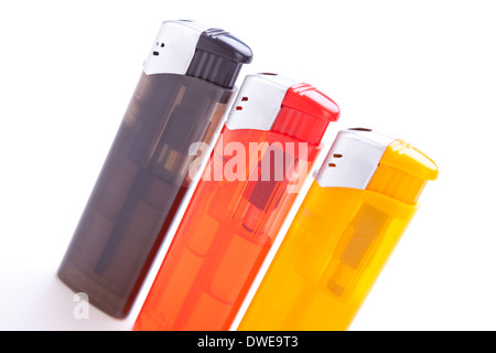 Row of vividly coloured plastic disposable lighters for smokers in red, yellow, two shades of blue and black isolated on a white background Stock Photo