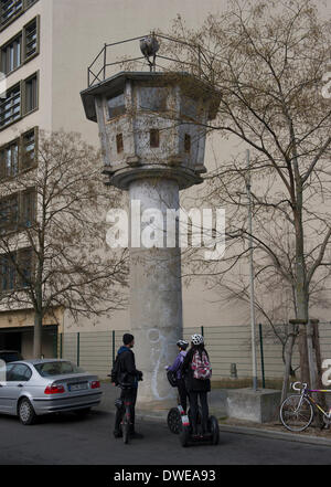 Berlin, Germany. 03rd Mar, 2014. Tourists stand at a former GDR watch tower close to Potsdamer Platz in Berlin, Germany, 03 March 2014. The building is part of the Berlin Wall path, a footpath leading pedestrians along the former inner German border. Photo: Paul Zinken/dpa/Alamy Live News Stock Photo