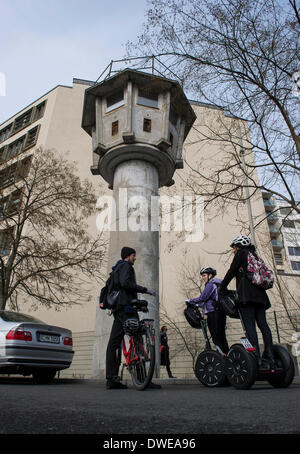 Berlin, Germany. 03rd Mar, 2014. Tourists stand at a former GDR watch tower close to Potsdamer Platz in Berlin, Germany, 03 March 2014. The building is part of the Berlin Wall path, a footpath leading pedestrians along the former inner German border. Photo: Paul Zinken/dpa/Alamy Live News Stock Photo