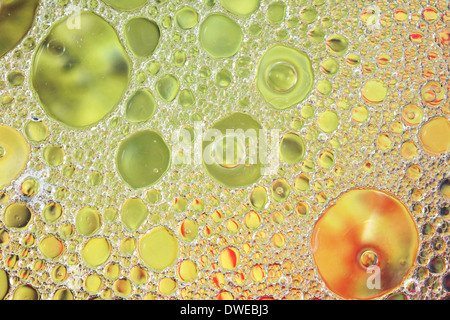 Oil and water over colorful gold and green background Stock Photo
