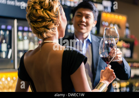 Asian Couple toasting in a wine shop Stock Photo
