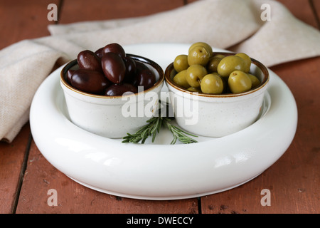 marinated green and black olives (Kalamata) in a ceramic bowl Stock Photo