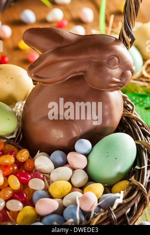 Chocolate Easter Bunny in a Basket with Assorted Candy Stock Photo