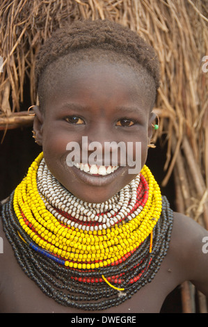 Nyangatom, Bume or Buma girl with bead necklaces in front of her hut ...