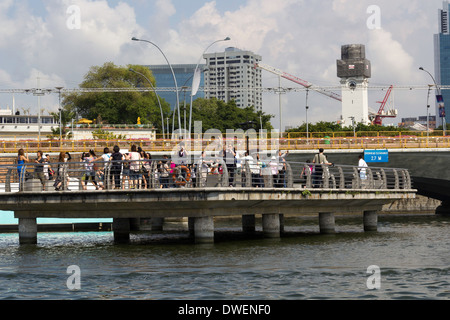 Visitors on viewing plaza on Singapore river next to the Merlion statue, built on a platform with support pillars Stock Photo