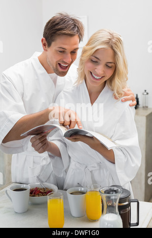 Happy young couple with recipe book in kitchen Stock Photo