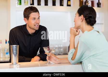 Woman talking to bartender at the bar counter Stock Photo