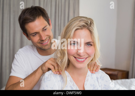 Smiling young man massaging woman's shoulders Stock Photo