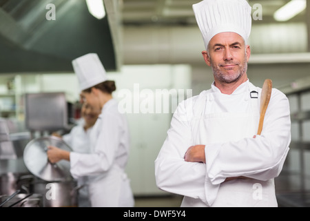 Head chef looking at camera holding wooden spoon Stock Photo