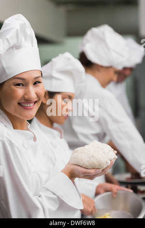 Happy chef holding dough smiling at camera Stock Photo